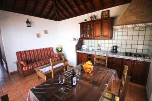 een keuken met een tafel en een fles wijn bij Casas los Alisios in Los Quemados