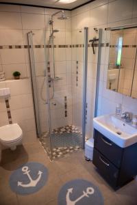 a bathroom with a shower and a sink and a toilet at Stüürhuus in Krummhörn