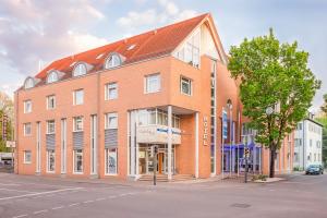 Un gran edificio de ladrillo en la esquina de una calle. en Hotel am Schillerpark, en Esslingen