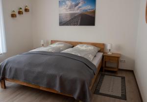 a bedroom with a bed with a picture on the wall at Stüürhuus in Krummhörn