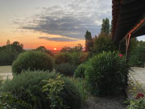 ThénacにあるRARE EXCLUSIVITE La Villa Fongrivoise Grande Piscine avec terrasse 5 chambres et salle de bain WC privatifs Patio Cheminée sans Vis à Visの夕日を背景に望む庭園