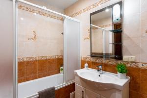 a bathroom with a sink and a shower and a mirror at Апартаменти in Ternopil +10 photos