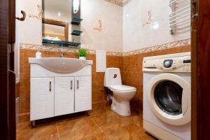 a bathroom with a sink toilet and a washing machine at Апартаменти in Ternopil