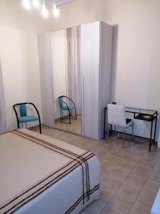 1 dormitorio con 1 cama, 2 sillas y escritorio en Appartamento centralissimo a Casciana Terme en Casciana Terme