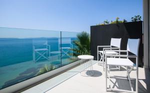 a balcony with two chairs and a table at Gallery Luxury Suites & Rooms-Only Adults in Split