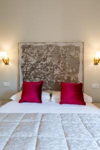 a bedroom with a large bed with red pillows at Doña Elvira Suites Cathedral in Seville
