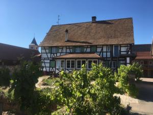 an old house with a roof on a street at La Ferme de Madeleine in Fessenheim-le-Bas