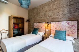 A bed or beds in a room at Doña Elvira Suites Cathedral