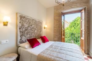 A bed or beds in a room at Doña Elvira Suites Cathedral