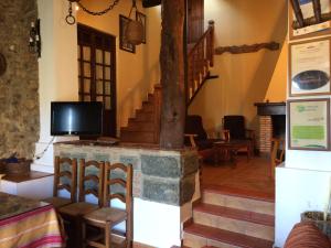 sala de estar con chimenea y TV en Casa Rural Finca El Tornero, en Aracena