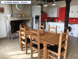 a wooden table and chairs in a kitchen with a fireplace at The Barn Complex in Argenton lʼÉglise