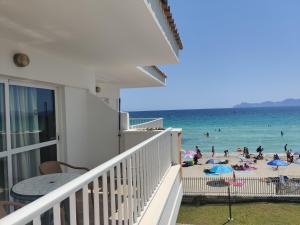 Un balcón de una casa con gente en la playa en Mar Blau en Port d'Alcudia