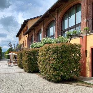 a building with a row of bushes in front of it at Tenuta La Cascinetta in Buriasco