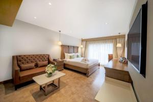 salon z kanapą i łóżkiem w obiekcie Jade Suites - Luxury Boutique Hotel w mieście Widźajawada