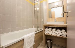 a bathroom with a tub and a sink and a mirror at Résidence Odalys Archipel in La Rochelle