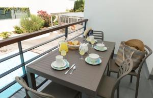 a table with cups and plates of food on a balcony at Résidence Odalys Archipel in La Rochelle