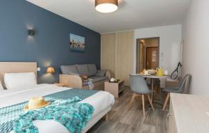 a bedroom with a bed and a couch and a table at Résidence Odalys Archipel in La Rochelle +28 photos