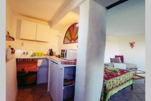 a kitchen with a sink and a microwave in a room at Casa Mariposa in Casares