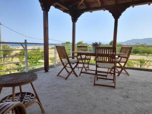 a patio with a table and chairs and a view of the ocean at The veranda appartment with sea view in Agiokampos