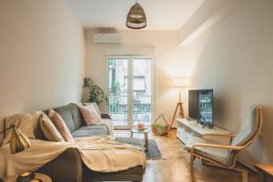 ein Wohnzimmer mit einem Sofa und einem TV in der Unterkunft 90m2 Luxury Apartment in the Heart of Athens - Living Stone Sunstone in Athen