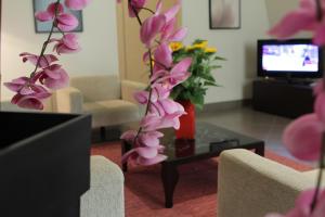 salon z wazą kwiatów na stole w obiekcie Le Magnolie Hotel w mieście Modica