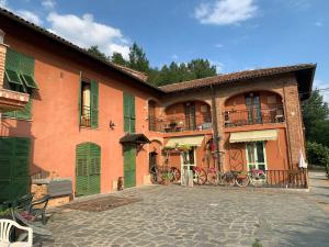 a large orange building with green doors and a patio at Casa Tavasso in Asti