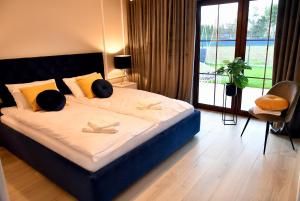 1 dormitorio con 1 cama grande y ventana grande en Apartamenty na Dworskiej, en Spytkowice