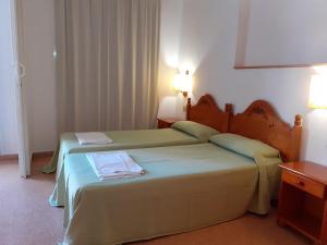 two beds in a hotel room with two lamps at Apartaments Mar Blau Calella in Calella