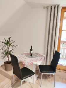 ein Esszimmer mit einem Tisch und 2 Stühlen in der Unterkunft Pension Treissmann in Pichling bei Stainz
