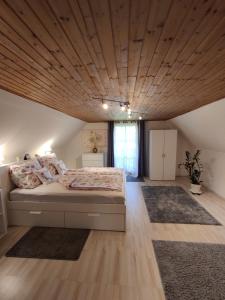 a bedroom with a large bed with a wooden ceiling at Pension Treissmann in Pichling bei Stainz