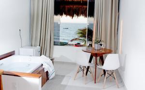 a bathroom with a tub and a table and a window at Villa Água de Côco Preá in Prea