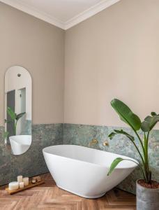 baño con bañera blanca grande y planta en Hotel Noel Jerusalem en Jerusalem