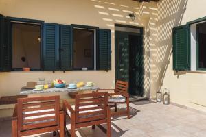 un patio con 2 sedie, un tavolo e alcune finestre di Villa Meitani a Kattavía