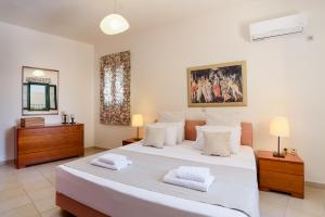 Un dormitorio con una gran cama blanca con dos almohadas. en Villa Meitani, en Kattavía