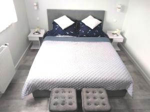 1 dormitorio con 1 cama blanca y 2 mesitas de noche en Apartament Relax Garden, en Kołobrzeg