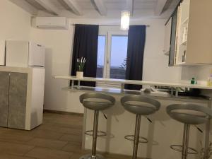 una cucina con due sgabelli e una finestra di Appartamento confortevole a Cagliari