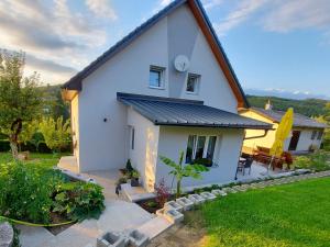 una casa blanca con techo negro en Privatzimmer Roland, en Hutten