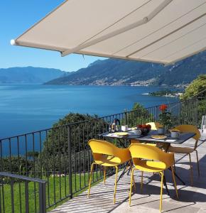 a table and chairs on a balcony with a view of the water at Ca' del Barba in Domaso