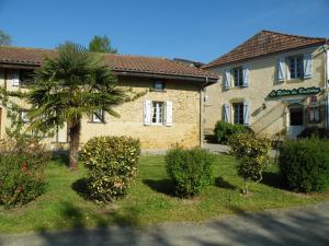 a house with a palm tree in front of it at Logis Le Relais du Bastidou in Beaumarches