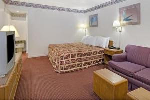 Habitación de hotel con cama y sofá en Captain John Smith Inn Williamsburg en Williamsburg