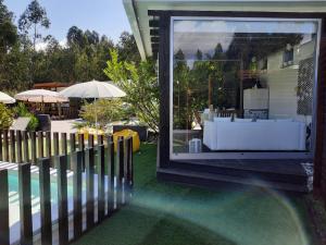 Cette chambre offre une vue sur une maison dotée d'une fenêtre et d'une piscine. dans l'établissement Villas do Rosal, à Boa Vista de Cima