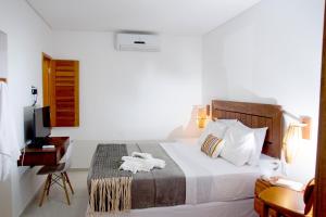 - une chambre avec un lit, un bureau et une télévision dans l'établissement VILLA ÁGUA DE COCO PREÁ, à Prea