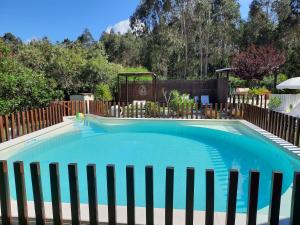a swimming pool in a fence with a blue at Villas do Rosal in Boa Vista de Cima