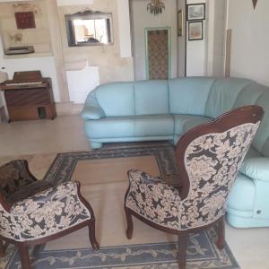Villa Grazia في Latiano: غرفة معيشة مع أريكة زرقاء وكرسيين