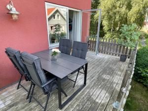 una mesa de madera y sillas en una terraza en Björkö, lägenhet nära bad och Göteborg en Gotemburgo