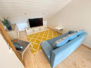 a living room with a blue couch and a television at Eva in Liepāja