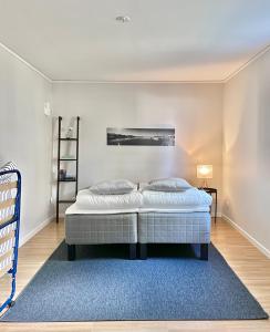 Duas camas num quarto com um tapete azul em Björkö, lägenhet nära bad och Göteborg em Gotemburgo