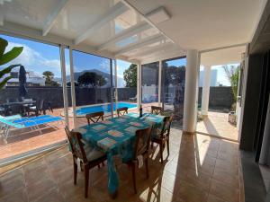 comedor con mesa, sillas y piscina en Varadero Nauplius, en Playa Blanca