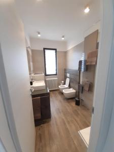 a bathroom with two sinks and a toilet and a mirror at Ca' del Barba in Domaso