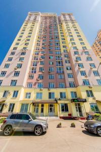 un grand bâtiment avec des voitures garées devant dans l'établissement Rent-Kiev 2 min metro Chernihivska Lux, à Kiev